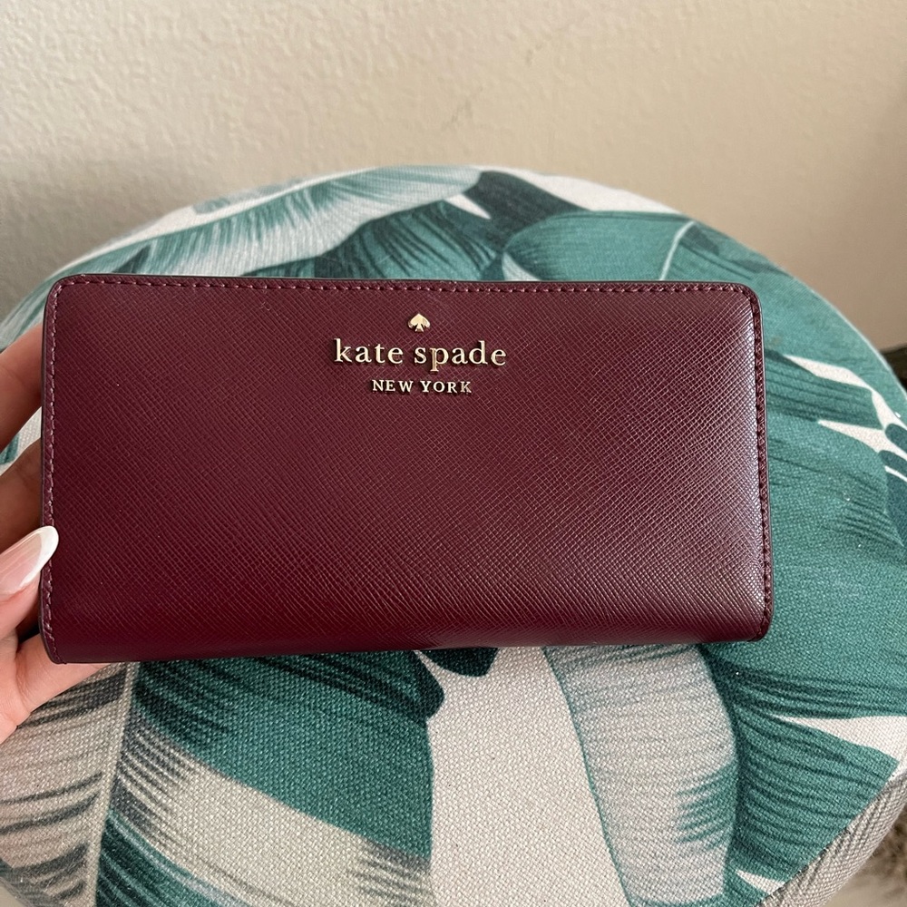 Kate Spade burgundy spencer slim bifold wallet.